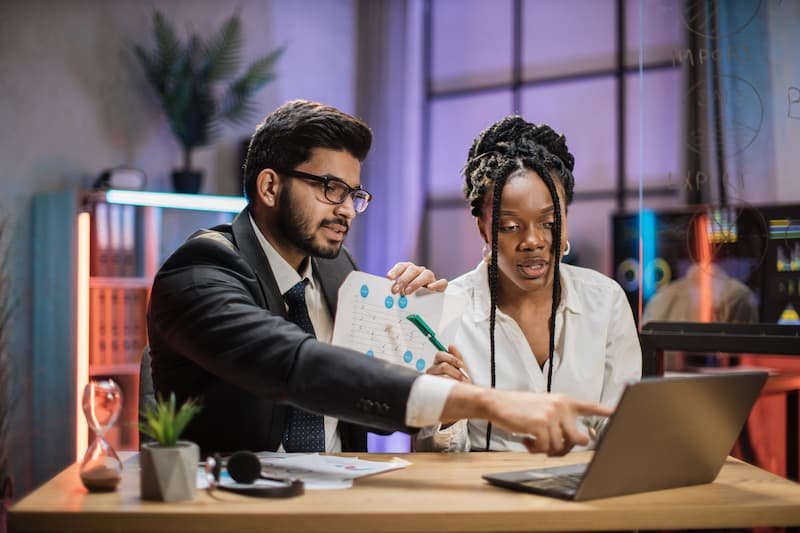 Consultants using a laptop and business data to improve systems